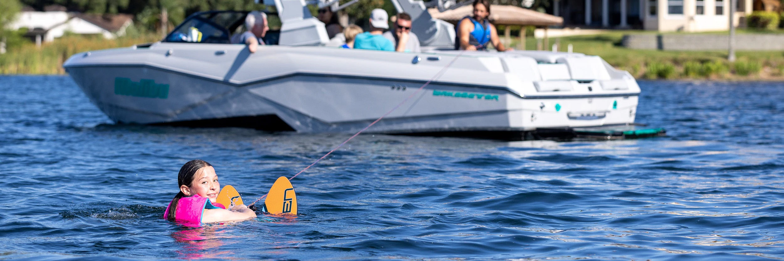 O’Brien 2024 All-Star Trainer Waterskis 1 Child floating in lake with O'Brien All-Star Trainer Waterskis preparing for deep-water start.