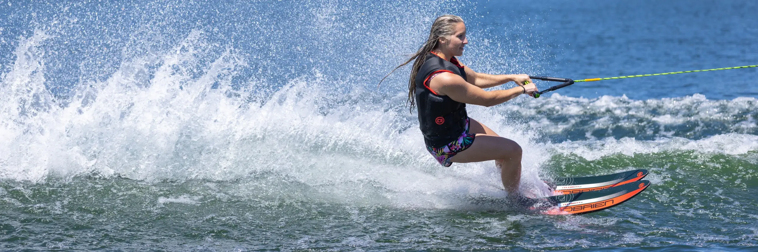 O’Brien Celebrity 64″ Combo Waterskis 1 Person water skiing on a body of water with a clear blue sky.
