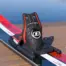 Close-up of a black ski binding on a red and white ski with a blurred blue background