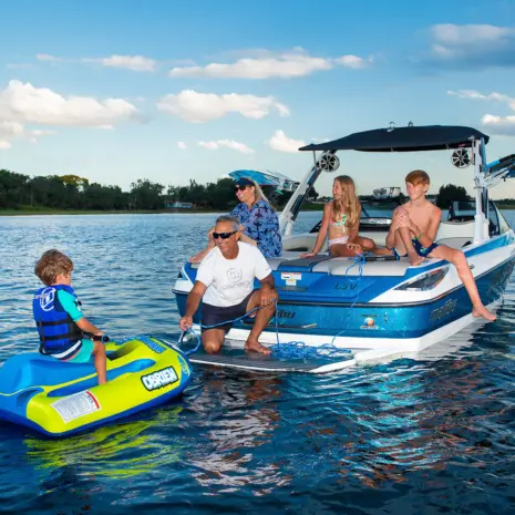 Obrien Simple Trainer Inflatable Ski Lifestyle 05 Family on a boat with a child on the O'Brien Simple Trainer Inflatable Ski in a lake.