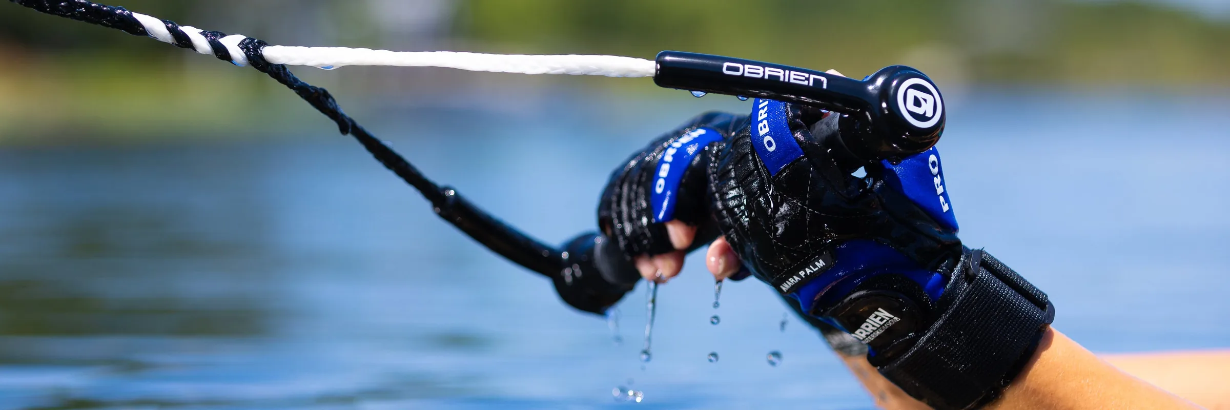 Wet gloved hand gripping an O’Brien watersports tow handle