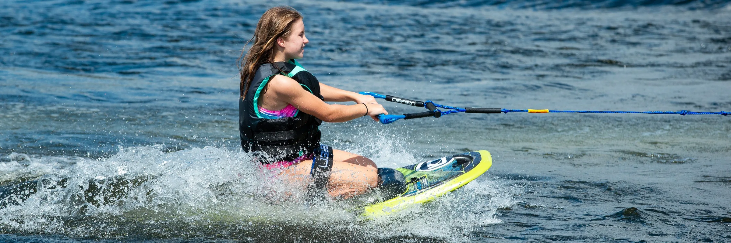 Young rider kneeboarding behind a boat on an O’Brien board