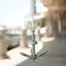 Aqua Marina anchor kit - folding anchor hanging from a white rope outdoors