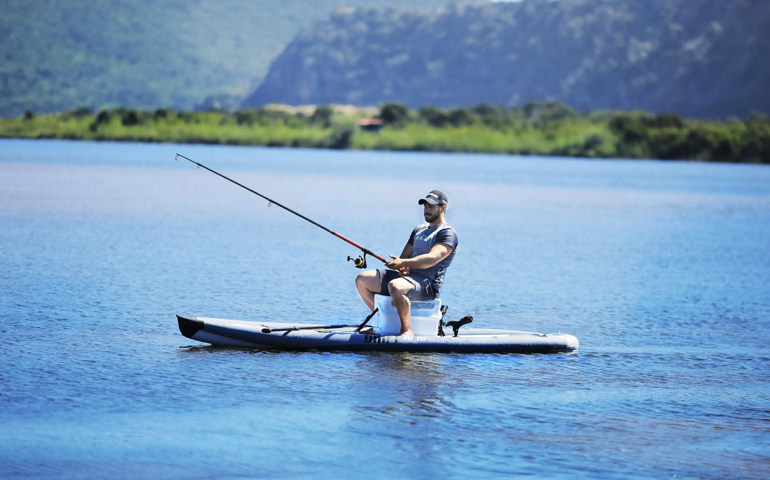 Aqua Marina Fishing Cooler Box 1 Aqua Marina fishing cooler box - angler seated on a cooler box on a paddle board