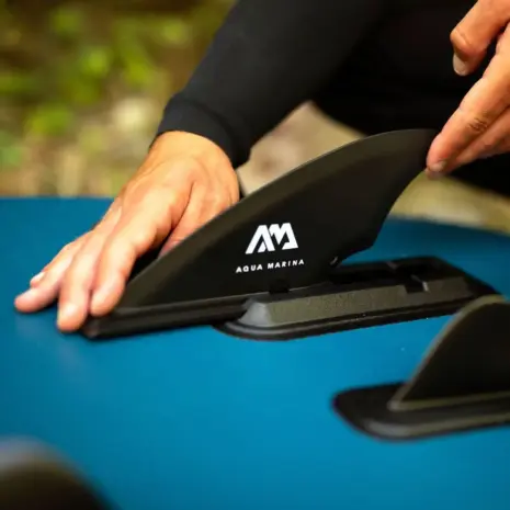 Aqua Marina slide-in river fin - person fitting the fin to a paddle board Aqua Marina slide-in river fin - person fitting the fin to a paddle board