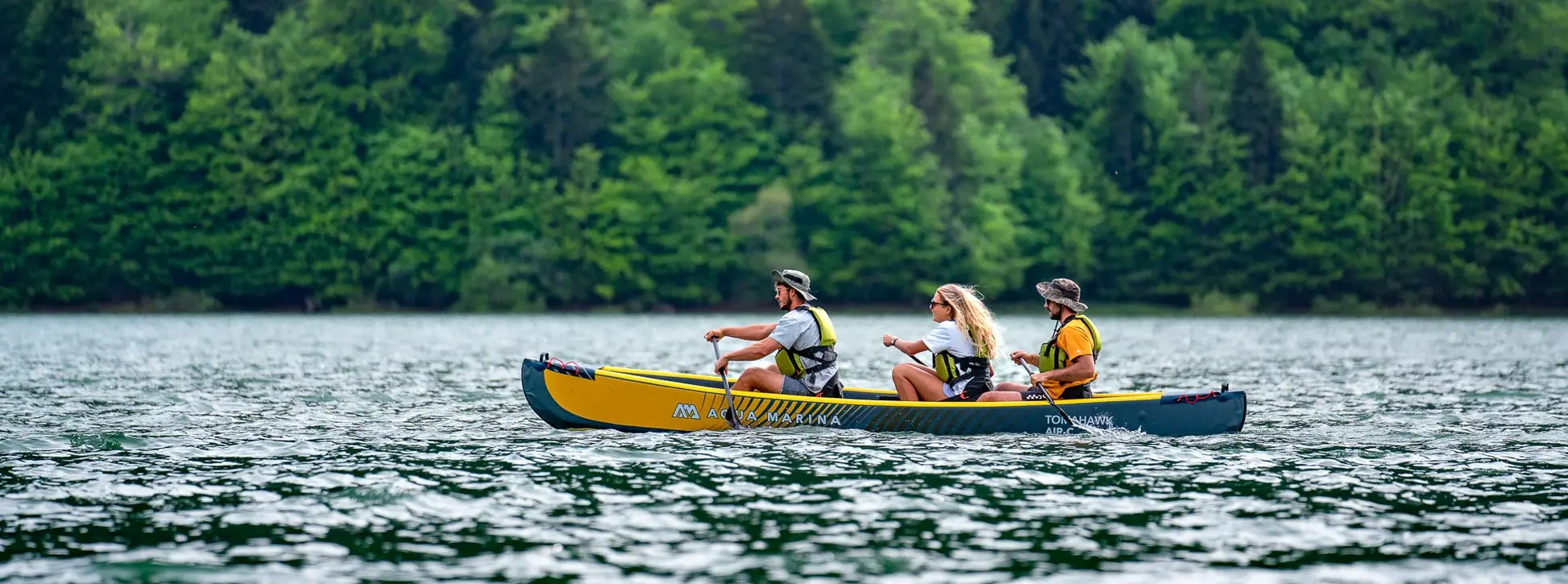 Aqua Marina Tomahawk AIR-C Triple Canoe 2 Aqua Marina TOMAHAWK AIR-C - side view of three paddlers in a canoe on a lake