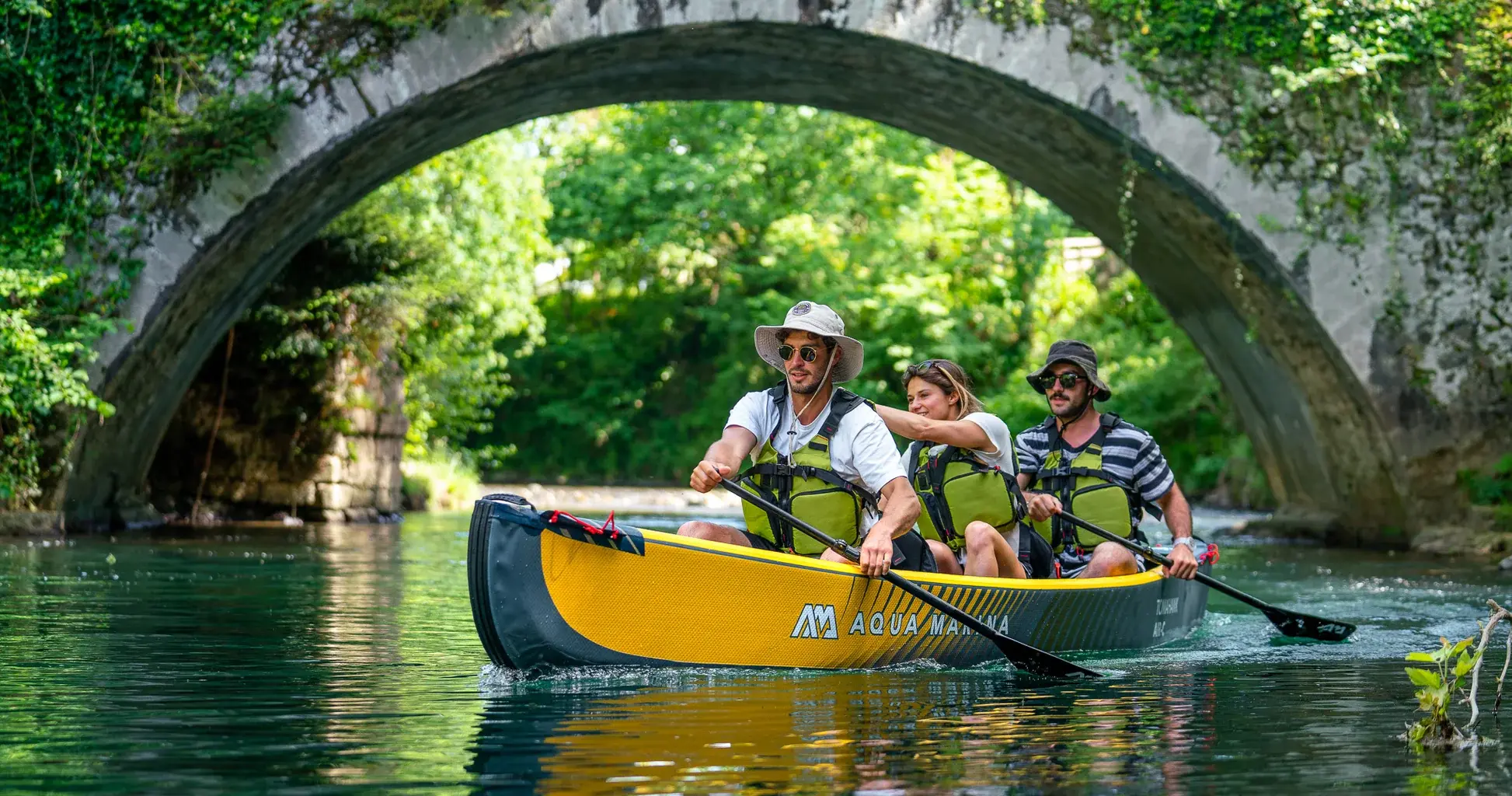 Aqua Marina Tomahawk AIR-C Triple Canoe 1 Aqua Marina TOMAHAWK AIR-C - three paddlers in a canoe beneath a stone bridge